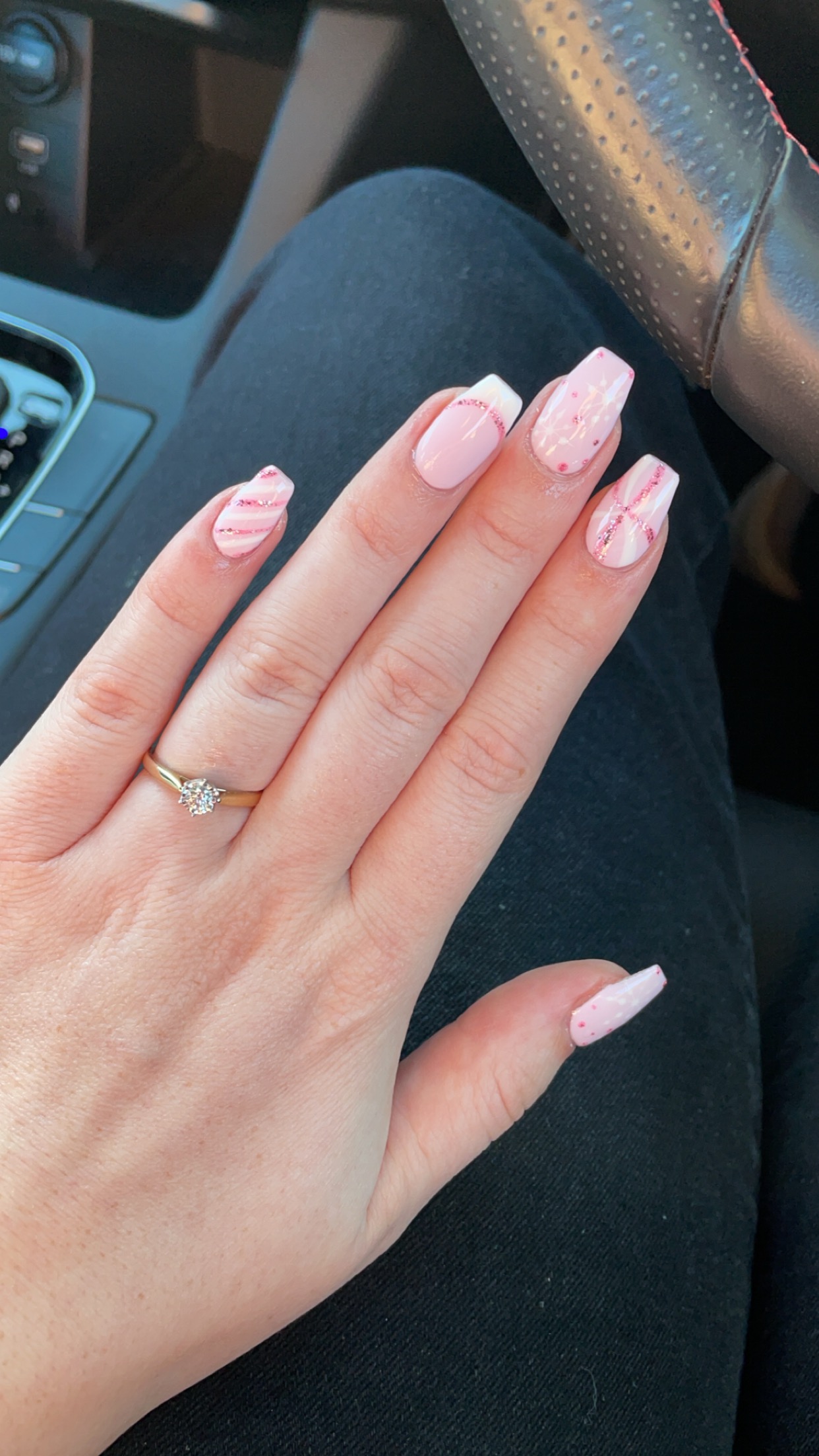 Pink and white striped nail art with glitter accents